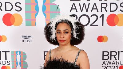 Celeste poses on the red carpet in a black feathered gown with a matching feathered headband for the Brit Awards. Reuters