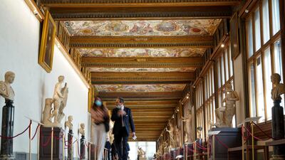 People walk in the Uffizi gallery during a press tour on the reopening day of the museum, in Florence. AP Photo