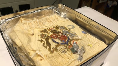 The slice of cake auctioned is in a tin containing plastic wrapped icing, it is one of the 23 official wedding cakes made for the royal wedding of Prince Charles and Lady Diana Spencer on Wednesday July 29, 1981 (Claire Hayhurst / PA via AP)