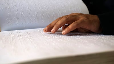 A visually impaired worshipper reads verses from the Quran at a mosque in Yemen's capital Sanaa. EPA