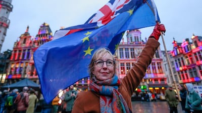 A woman holds a European flag and a Union Jack flag on the Grand Place in Brussels, Belgium. EPA
