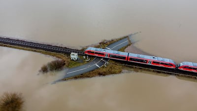 A train passes a rail road crossing that is surrounded by flooding caused by rain and melting snow in Nidderau near Frankfurt, Germany. AP