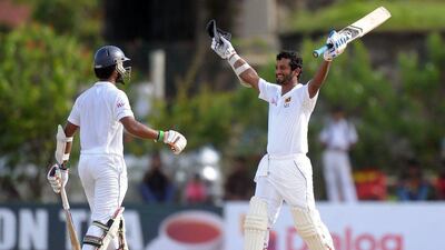 Sri Lanka bastmsan Dimuth Karunaratne celebrates a century on Wednesday during Day 1 of the first Test against West Indies. Lakruwan Wanniarachchi / AFP / October 14, 2015
