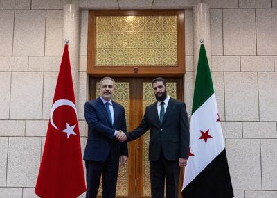 Turkish Foreign Minister Hakan Fidan and Syria's rebel leader Ahmed Al Sharaa shaking hands during their meeting in Damascus this month. EPA
