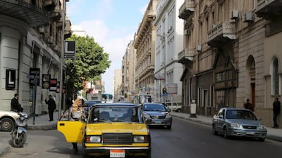 A woman gets into a yellow and black cab in front of L-Passage food hall on Fouad street in Alexandria.