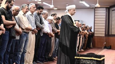 Mourners at the Lala Basha mosque perform prayers over Mr Khalifa's coffin