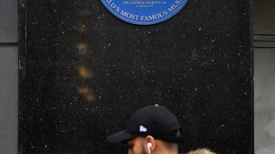 A blue heritage plaque is seen on the exterior of the building as a man passes the original branch of the HMV chain of music retailers in London, England. Getty Images