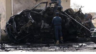 Policemen investigate at the site of a suicide car bomb blast in Lashkar Gah, capital of Helmand province, yesterday. REUTERS/Stringer