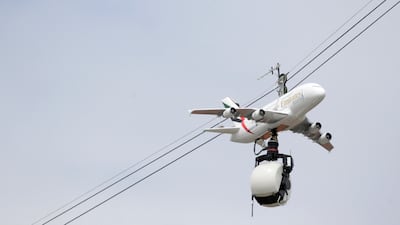 A plane model bearing the colours of Emirates holds a camera above the Roland Garros stadium on the opening day of the French Open tennis in Paris in 2013. AFP