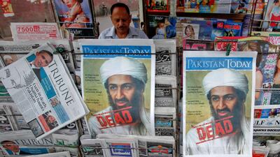 A roadside vendor sells newspapers with headlines about the death of Al Qaeda leader Osama bin Laden, in Lahore May 3, 2011.