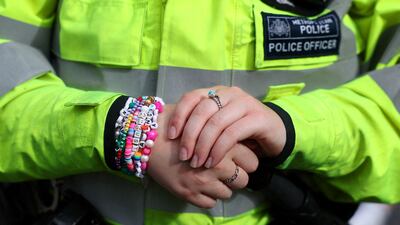 A police officer wears friendship bracelets while patrolling near Wembley. Reuters