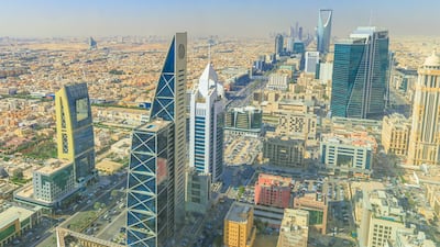 Panoramic view of Riyadh, Saudi Arabia, showcasing the vast urban sprawl, bustling streets, and modern architecture under a bright, sunny sky