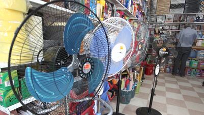 Fans in a general store in Algiers where the temperatures rose up to 30 degrees Celsius. AP