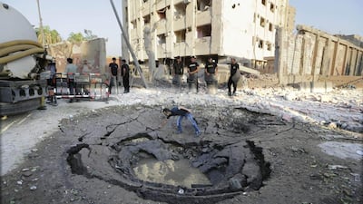 An Egyptian worker checks a crater caused by the car bombing of a Cairo police building early on August 20, 2015. Amr Nabil/AP Photo