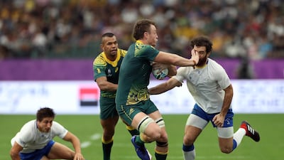 Jack Dempsey of Australia tries to evade Rodrigo Silva of Uruguay in Oita. Getty