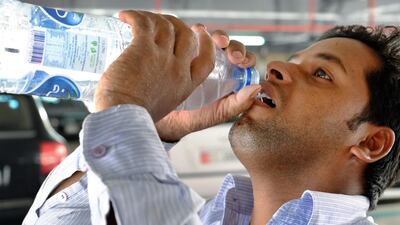 A worker drinks water to keep himself hydrated during a mandatory break for outdoor workers. The start of the mandatory break for outdoor workers across the UAE will last until September 15. Delores Johnson / The National