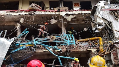 Bangladeshi firefighters take part in a search and rescue operation at a destroyed garment factory in Gazipur on July 4, 2017, after a boiler explosion at the complex on the outskirts of Dhaka. At least 10 people were killed and three remained missing on the second day of a boiler explosion incident at a garment factory in Bangladesh, officials said Tuesday. / AFP PHOTO / Munir UZ ZAMAN