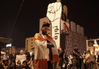 Anti-government protesters listen as President Michel Aoun delivers a televised speech. AP