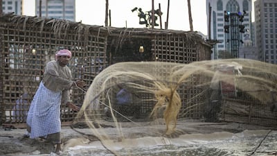 A fisherman casts his net in the Ocean Zone at this year’s Qasr Al Hosn Festival. Mona Al Marzooqi for The National