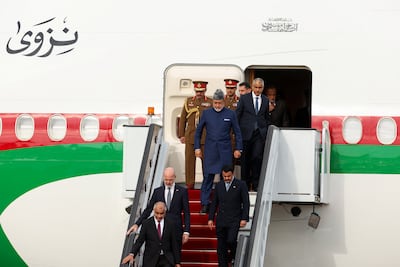 Sultan Haitham arrives at Stansted Airport wearing a blue suit with a tunic jacket and a grey Astrakhan hat. Reuters