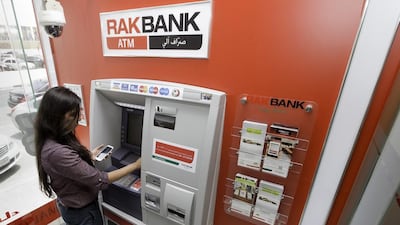 A RAKBank employee withdraws money from an ATM machine after using the new app. Jaime Puebla / The National