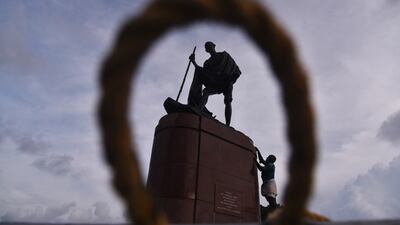 A man cleans a statue of Mahatma Gandhi, at Marina beach in Chennai, India. EPA