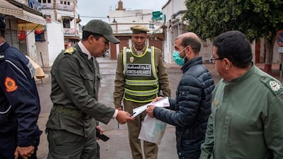 Members of Morocco's Interior Ministry Auxiliary Forces instruct a man to return home in the capital Rabat, Morocco. AFP