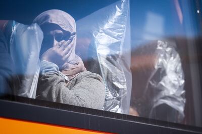 A woman stares out from a bus that will take her and other migrants for processing, in Dungeness, on the south-east coast of England, in August. AFP