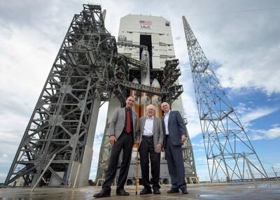 Astrophysicist Eugene Parker, centre, stands in front of the rocket carrying the solar probe named after him. Nasa via AP