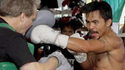 Manny Pacquiao, right, spars with his trainer Freddie Roach, left during a media workout in Los Angeles yesterday.