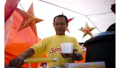 Judy Ubayan serves food at his booth, which is an extension of Goto King, a Filipino food franchise, at a fundraising bazaar at the Philippine embassy.