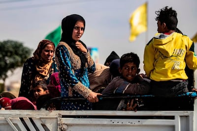 Displaced Syrians sit in the back of a pick up truck as Arab and Kurdish civilians flee amid Turkey's military assault on Kurdish-controlled areas. AFP