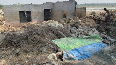 Shafi Jan repairs his home that was destroyed in the floods.