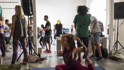 A sunriser finds balance during a yoga pose while the DJ’s continue to pump bright dance music into the morning air.