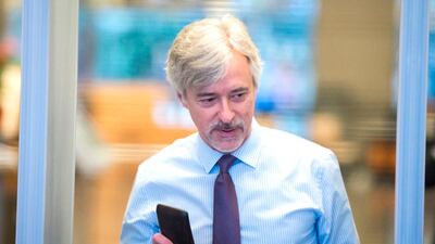 Waymo CEO John Krafcik shows his wallet has he arrives at the Phillip Burton Federal Building and United States Courthouse for the start of the Waymo vs Uber trial in San Francisco. AFP/JOSH EDELSON