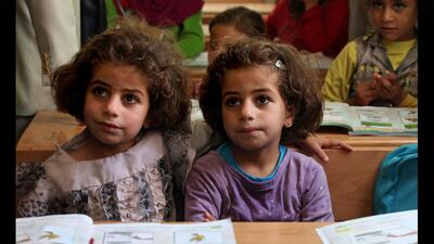 Twin sisters, who fled Syria with their family, sit at their desks at the UNICEF school, during a visit by the Italian foreign minister, Emma Bonino to the Zaatari refugee camp near the Syrian border, in Mafraq, Jordan. Mohammad Hannon / AP Photo