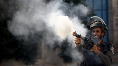 An Israeli policeman fires tear gas canisters during clashes with Palestinian protesters in the West Bank city of Hebron last week. Mussa Qawasma / Reuters