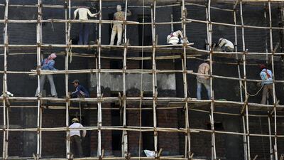 Indian labourers work on a wooden scaffolding at a construction site in Mumbai, India, on February 11, 2014. According to reports, India’s economic growth rate is expected to be 4.9 per cent, compared to 4.5 in the previous year. Divyakant Solanki / EPA