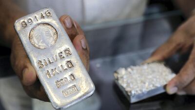 Faisal, the owner of Sharjah's Al Baroon Gold Factory, holds up a 1kg silver bar used for making jewellery. Pawan Singh / The National