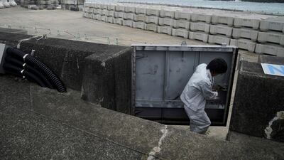 A Kiho town official closes a door of a coastal levee. AP