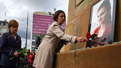 First minister of Scotland Nicola Sturgeon, left, and leader of Scottish Labour Kezia Dugdale place roses at a memorial for murdered Labour MP Jo Cox, in Glasgow in 2016
