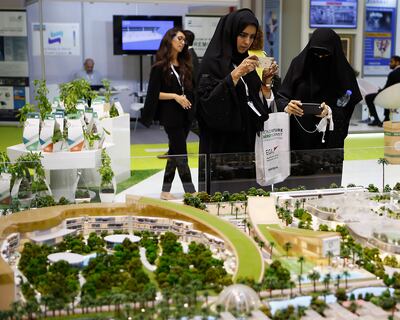 Visitors take photographs of Sustainable City in Dubai, the region's first net-zero operational sustainable community model displayed at the World Future Energy Summit 2017 at the Abu Dhabi Exhibition Centre. Photo: Ravindranath K / The National