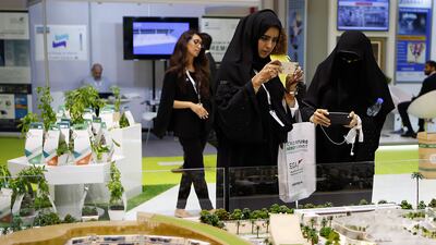 Visitors take photographs of Sustainable City in Dubai, the region's first Net Zero Operational Sustainable community model displayed at the World Future Energy Summit 2017 at the Abu Dhabi Exhibition Centre. Ravindranath K / The National