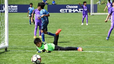 Desert Rangers (blue/black) from Dubai vs. Al Ain Football Club (purple) under 8 age group.