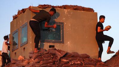 Syrian demonstrators vandalise a Turkish army observation point in Ibbin Samaan. AFP