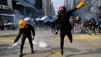 Protesters throw the tear gas canisters fired by riot policemen during a rally in Hong Kong. AP Photo