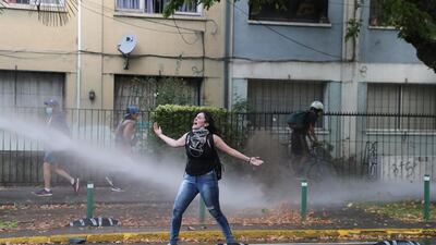A woman shouts slogans at riot police during a protest after a police officer shot dead a street juggler in broad daylight in Panguipulli, Chile. Reuters.