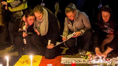 Brussels airport workers and their relatives pay tribute to the victims of Brussels triple attacks at a makeshift memorial near the airport in Zaventem on March 23, 2016. Philippe Huguen / AFP