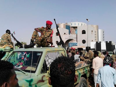 Sudanese soldiers look on as demonstrators gather in a street in central Khartoum. AFP
