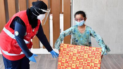 A gift is dropped off to a household by a staff member from Dubai's Community Development Authority. The authority has launched an initiative to help support families who are in quarantine for Covid-19. Courtesy: Dubai's Community Development Authority